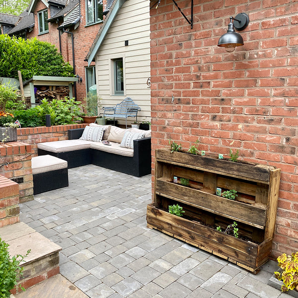 A rustic outdoor space with potted plants and industrial lighting