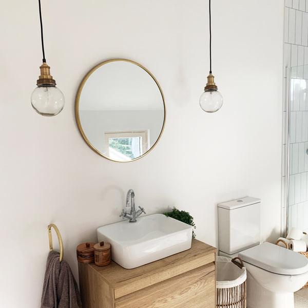 A white bathroom with a mirror and pendants