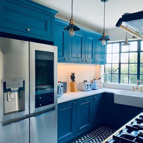 A blue kitchen interior with large window and industrial lights by Industville