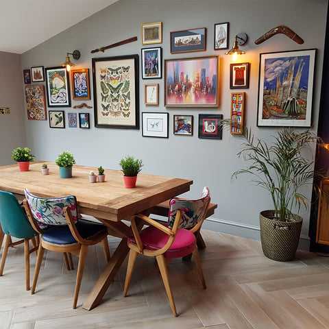 A dining table by a gallery wall