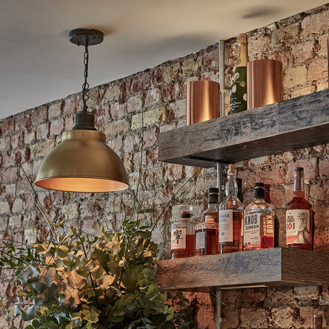 A rustic bar interior with exposed brick and metal lights