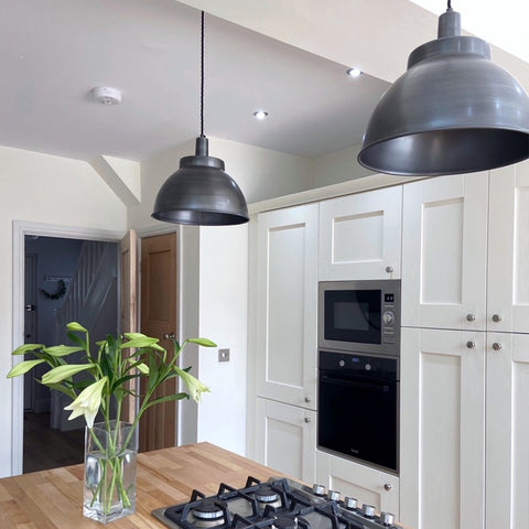 A modern kitchen with white cupboards and wooden work surface