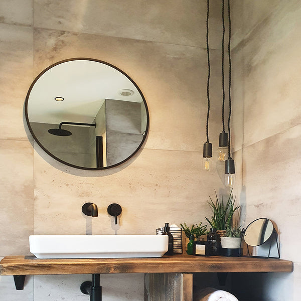 An industrial-style bathroom with hanging lights by Industville