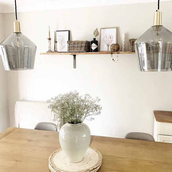 Two Industville grey tinted glass shades hanging over a dining table