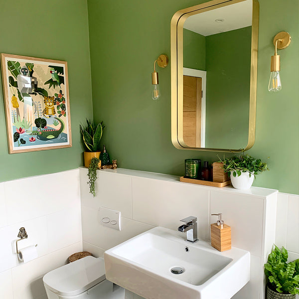 A green bathroom with brass features
