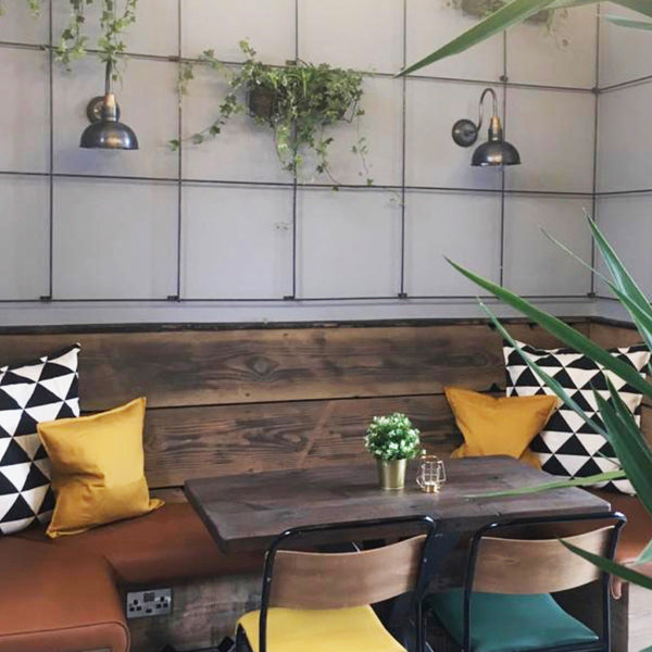 An industrial restaurant interior with wooden tables and plants