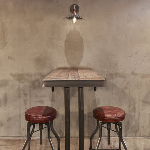 A wooden table with leather industrial stools