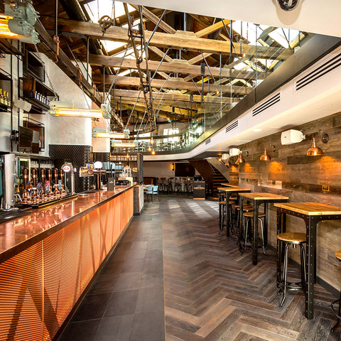 wooden side tables underneath metal industrial lighting