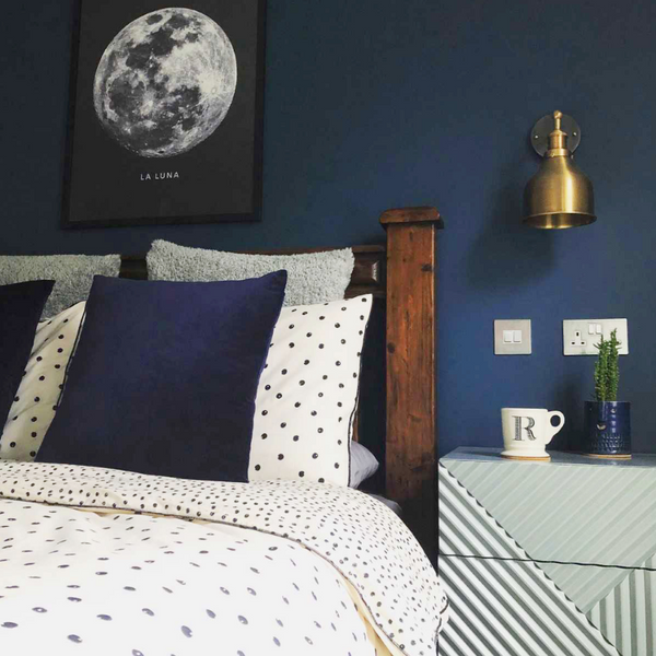 A bedroom with blue painted wall and gold details