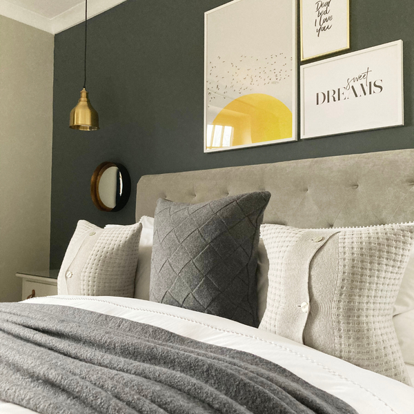 A grey bedroom with yellow details