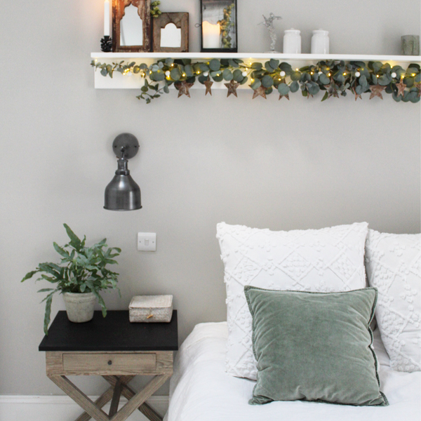 A white bedroom with green decorations