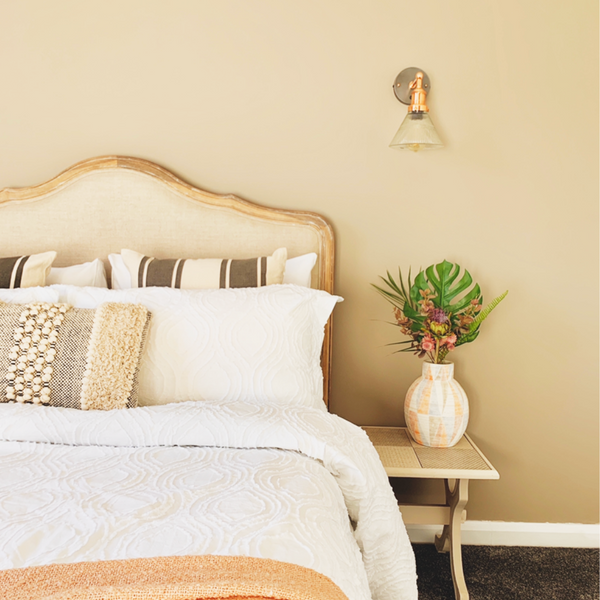 A yellow bedroom with a wall-mounted light