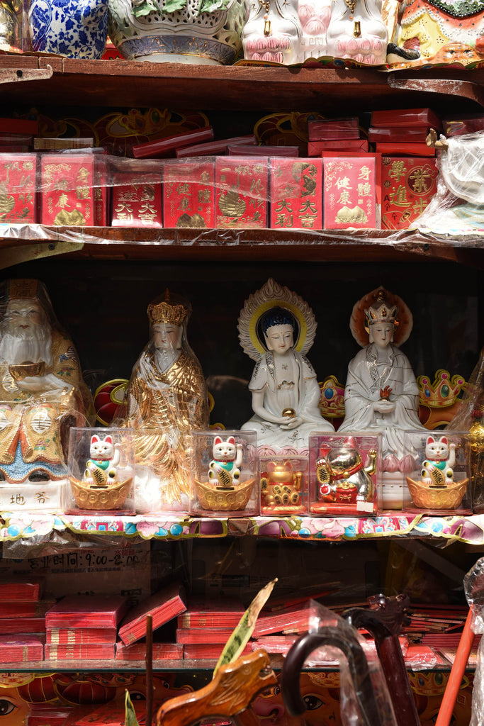 Shelves lined with statues and worshipping items of Buddhist deities. 
