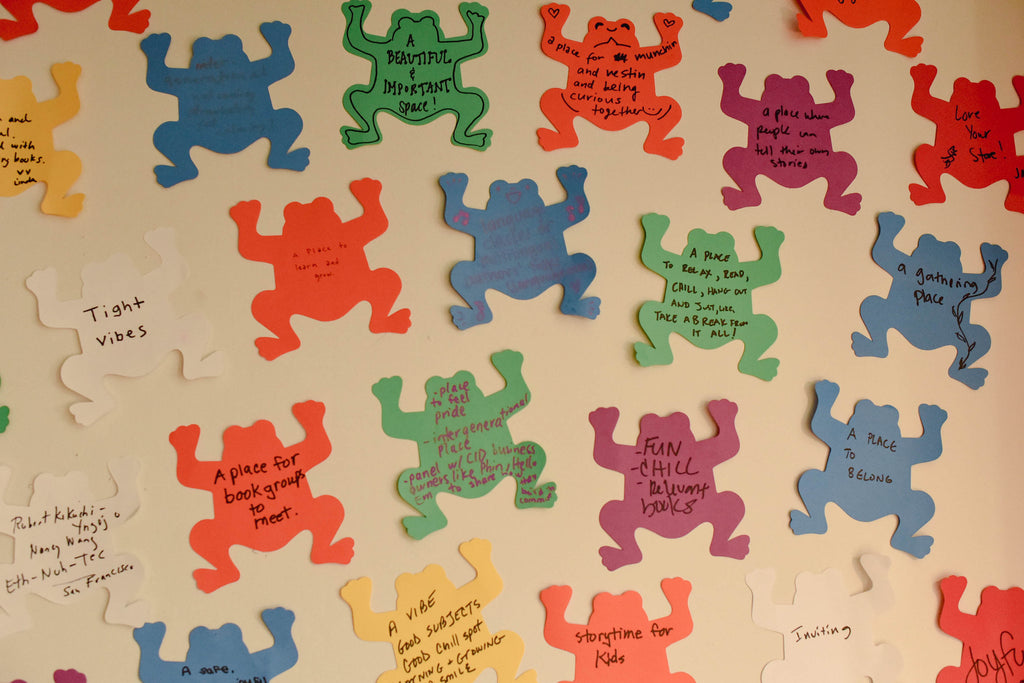 Frog shaped personal messages from supporters of the bookstore adorn the wall inside the store.