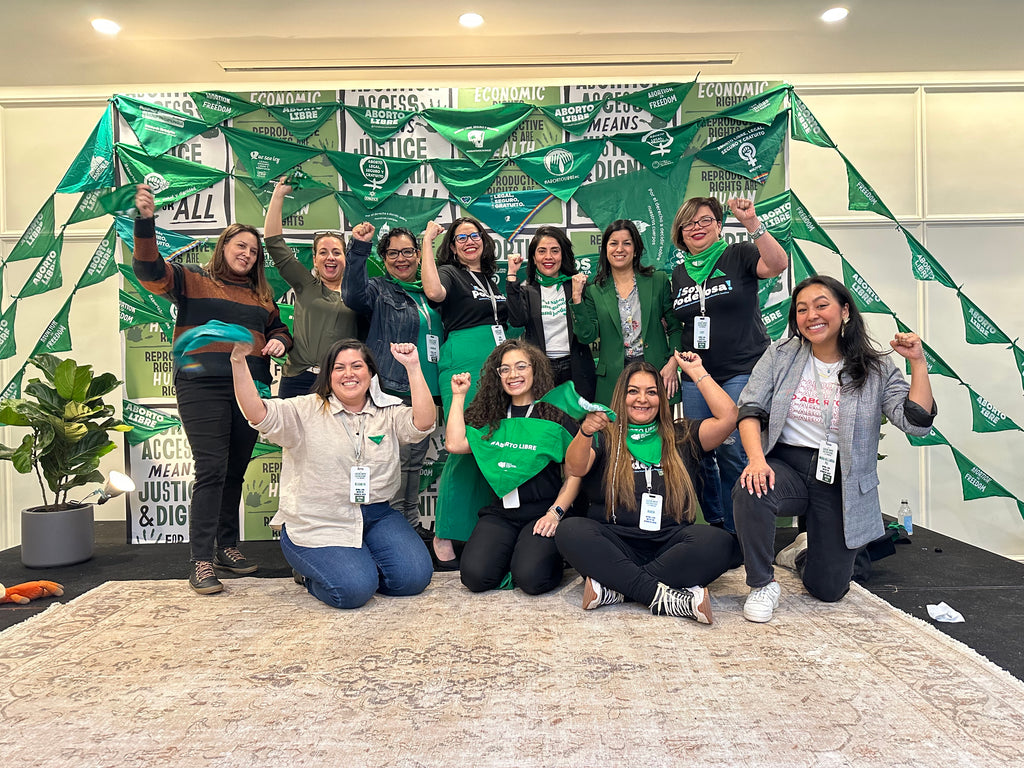 A group of Latina/x women pose for a photo together as part of the Green Wave Staff of the Latina Institute.