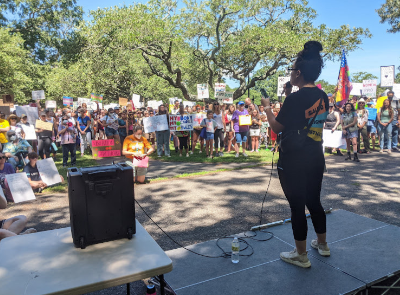 A woman standing on a podium addressing a crowd.