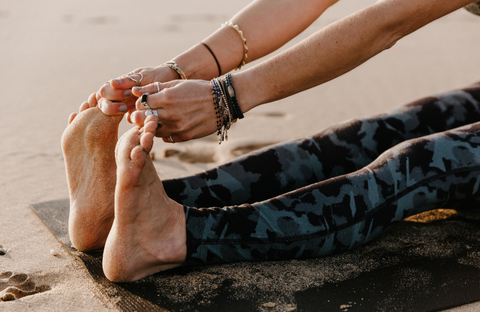 Women performing yoga on the seashore