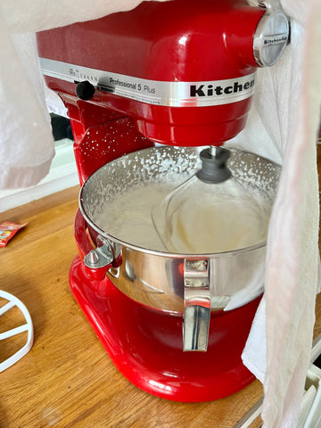 kitchenaid mixer red with cream whipping to make butter kitchen towel over