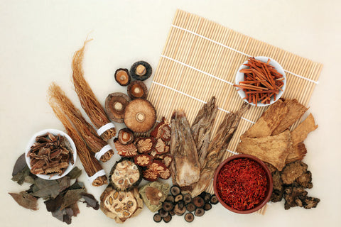 A flat lay view of a range of medicinal mushrooms on a white bench. 