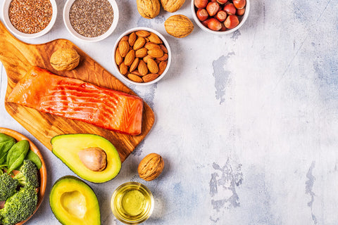 A flat lay or bird's eye view of foods rich in Omega 3 — including fish, avocado, seeds and more