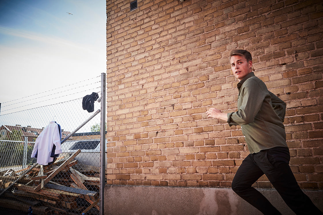 John running in front of a brick wall