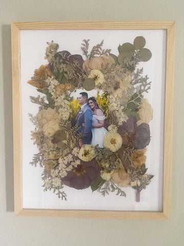 Kate's pressed wedding bouquet frame hung up in the home.