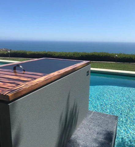 RENU Therapy cold plunge tank in backyard overlooking a pool and the ocean