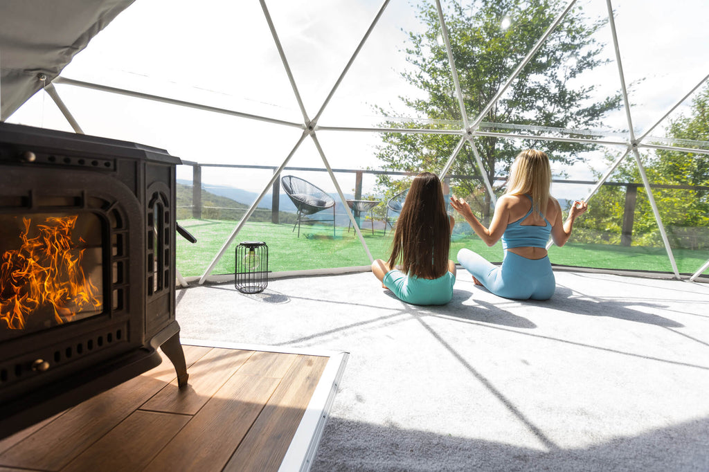 a mother and daughter sitting in geodesic dome tent during yoga retreat