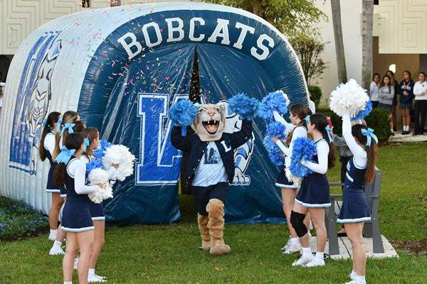 custom inflatable tunnel with mascot and cheerleaders in foreground