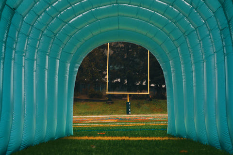 green inflatable MVP Visuals tunnel on a football field  