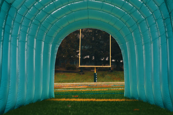 green custom inflatable tunnel on football field