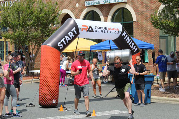 participants cheering at start line with inflatable arch