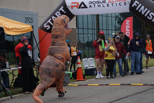 performer wearing an inflatable mascot in front of an archway