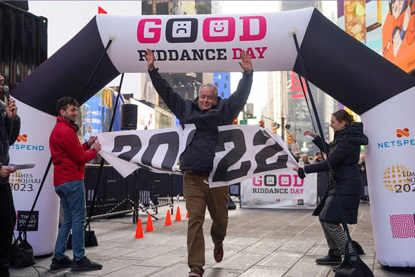 person crosses finish line marked by inflatable arch