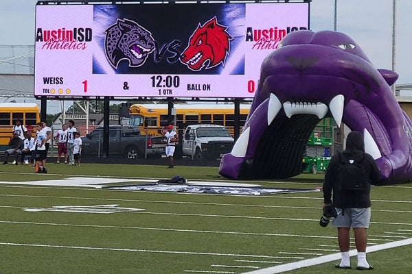 purple mascot tunnel on football field sidelines