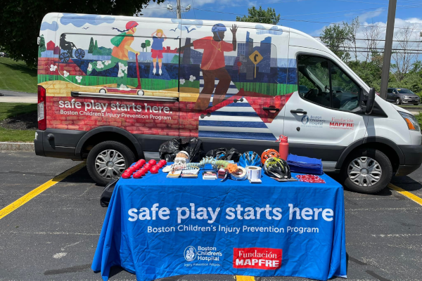 blue branded tablecloth on table next to branded van