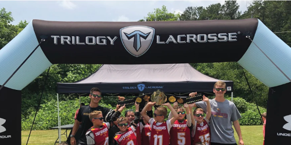 athletes holding medals at Trilogy Lacrosse custom inflatable arch