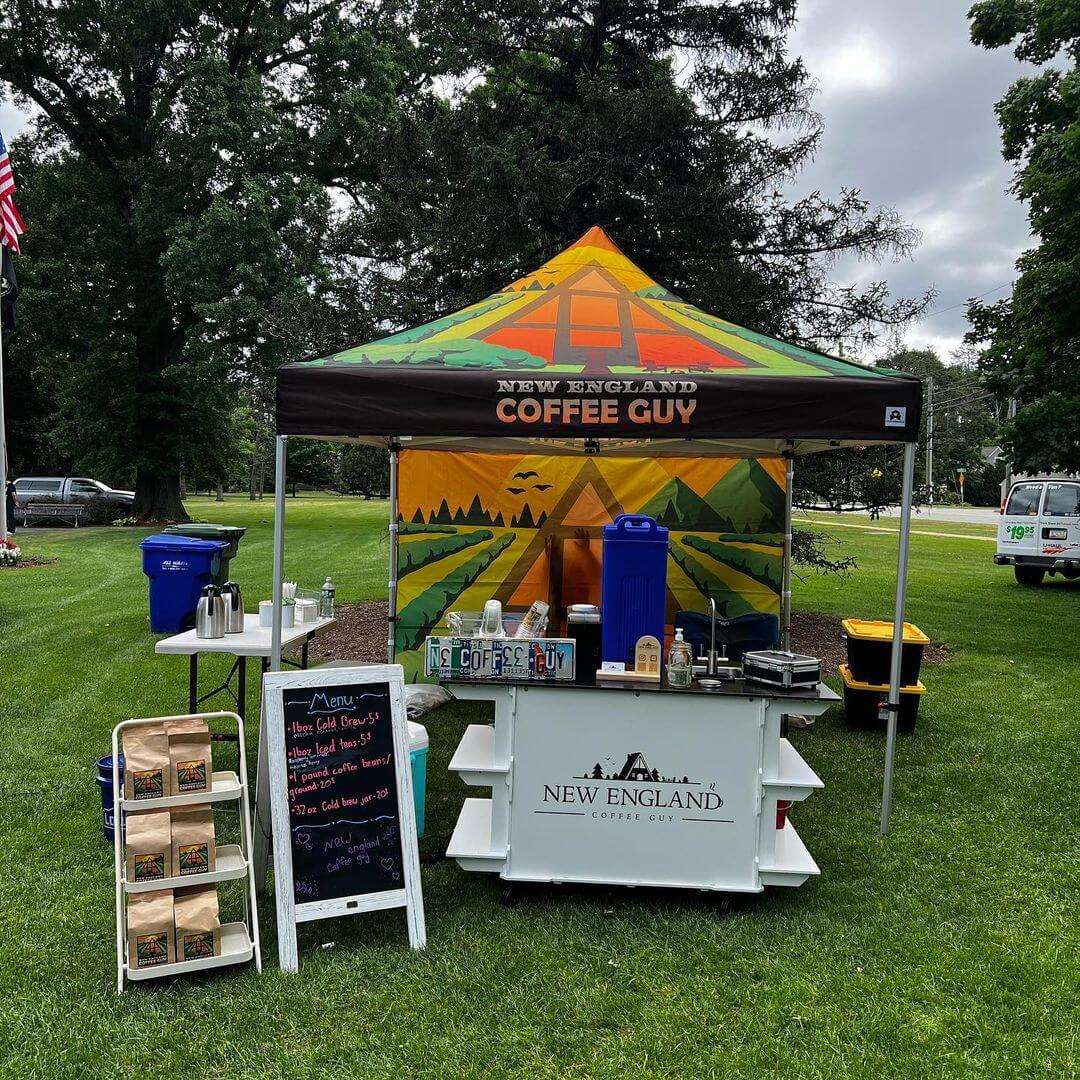 outdoor vendor booth setup of new england coffee guy with custom canopy, product stand and samples