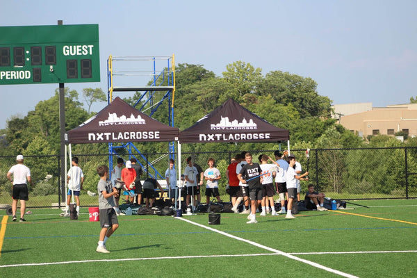 NXT Lacrosse using weight bags to secure their canopy tents