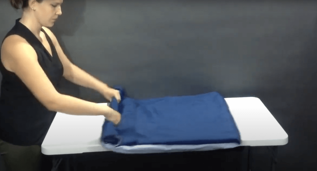 a tablecloth being rolled to prevent wrinkling