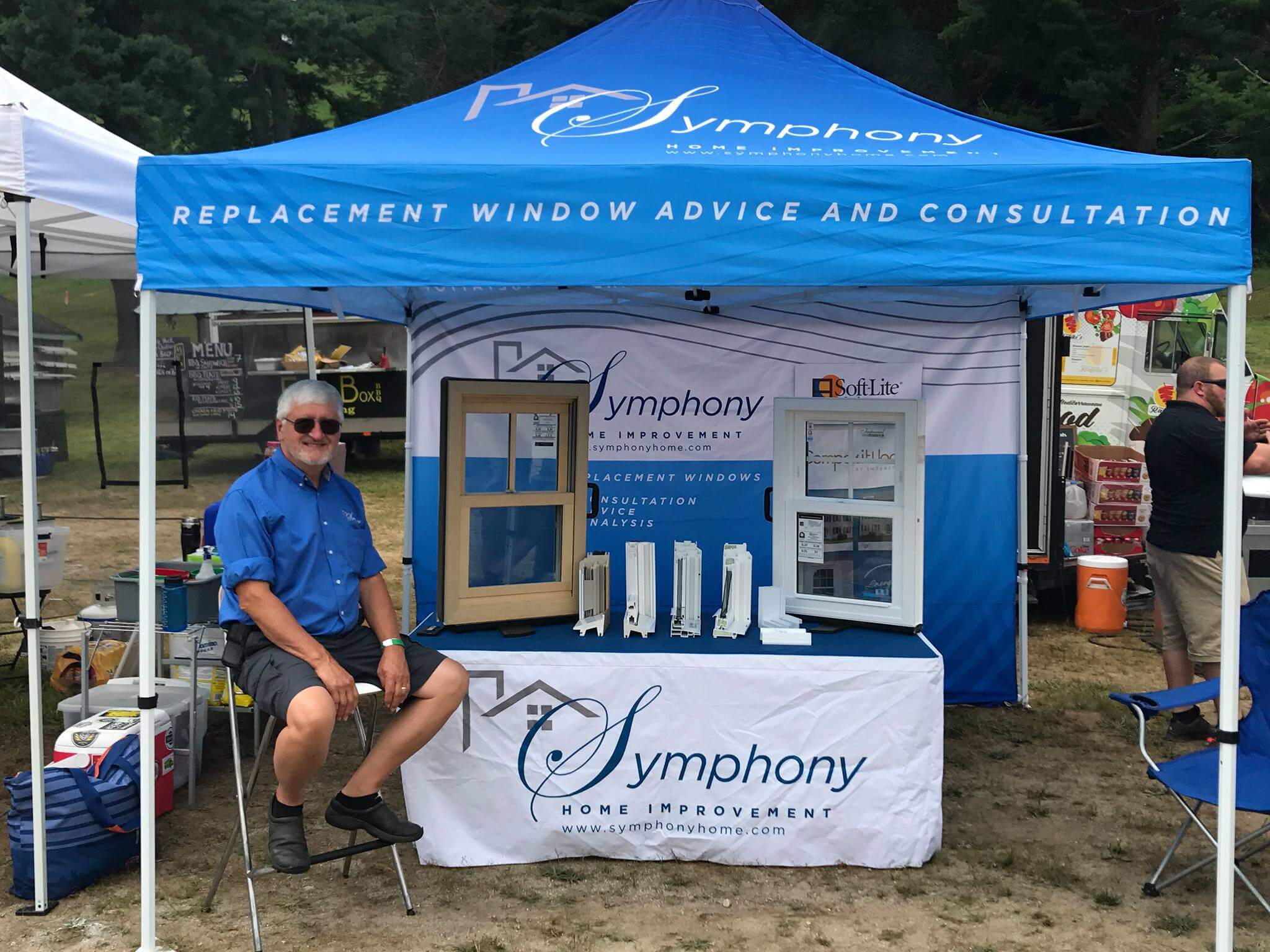 symphony home improvement's outdoor vendor setup with tactile product displays and an engaging representative