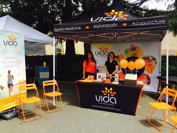 Vida Integrated Health booth at a farmers market offering holistic healthcare services