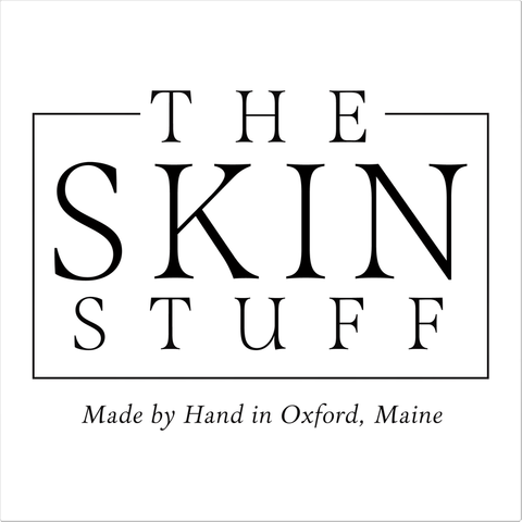 Text on white background. Text on top: The Skin Stuff. Text on bottom: Made by Hand in Oxford, Maine