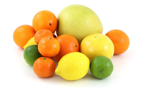 lemons limes oranges and grapefruit in a pile on white