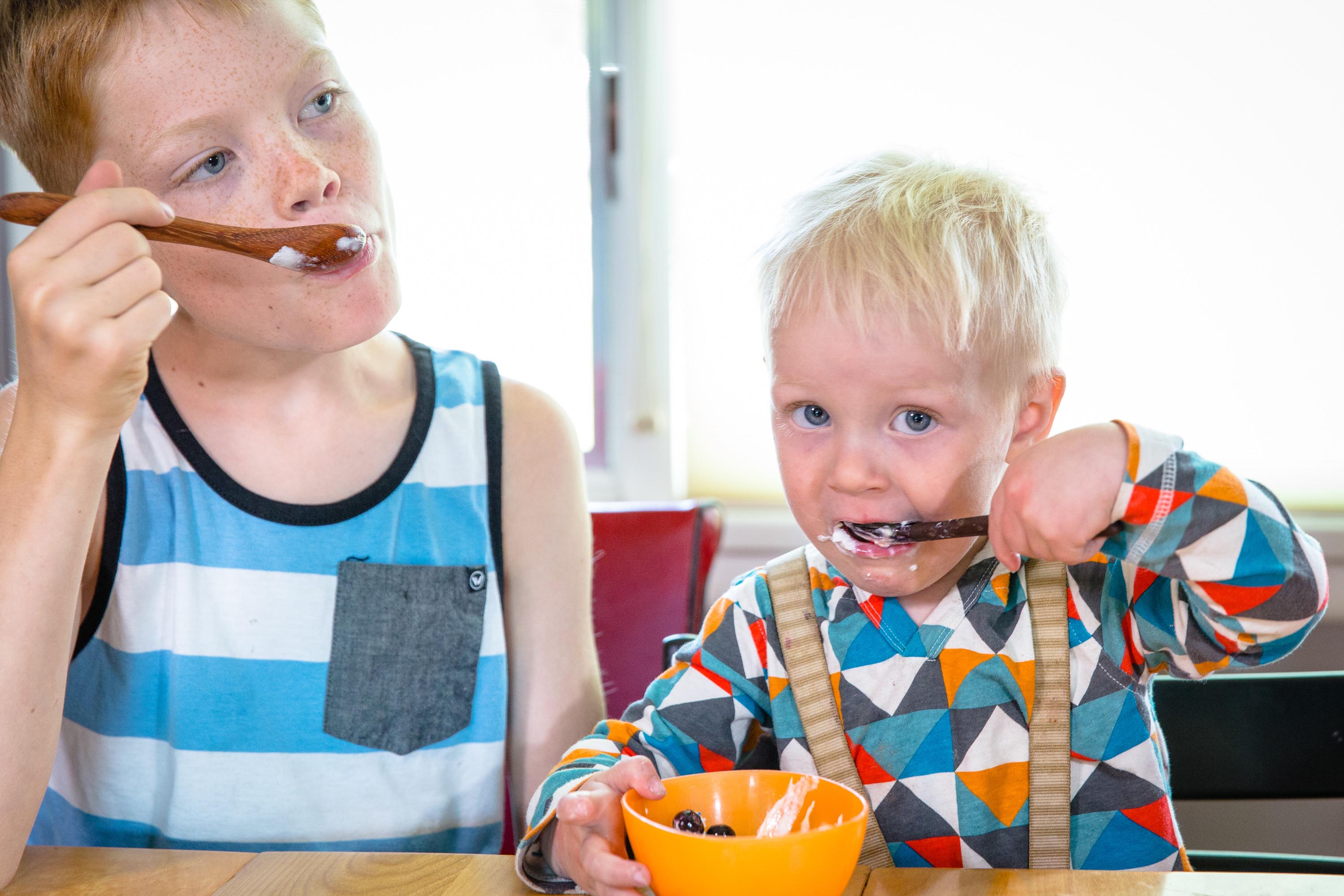 Kids using wooden spoons for eating