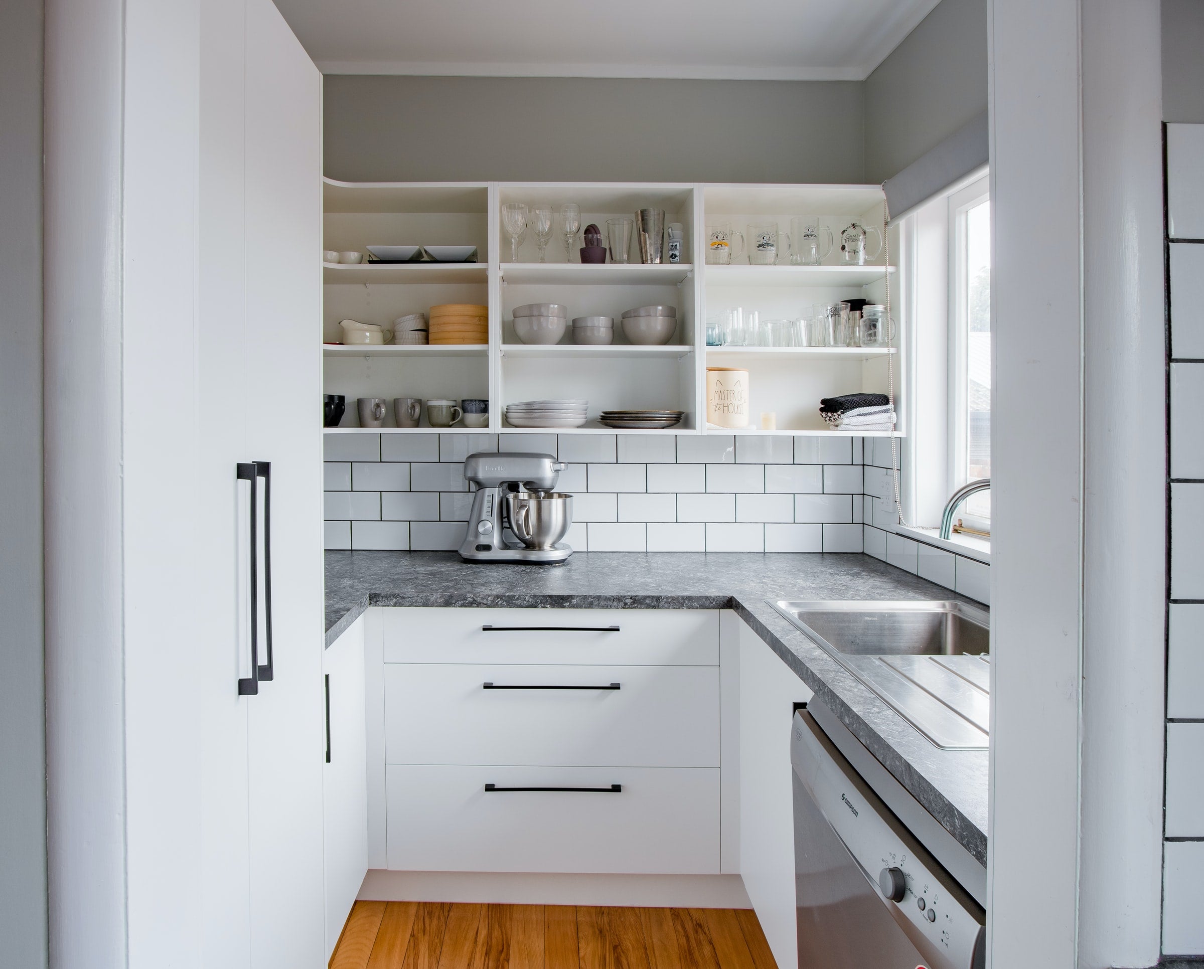 Utensils, plates, glasses, etc. organized by category in kitchen