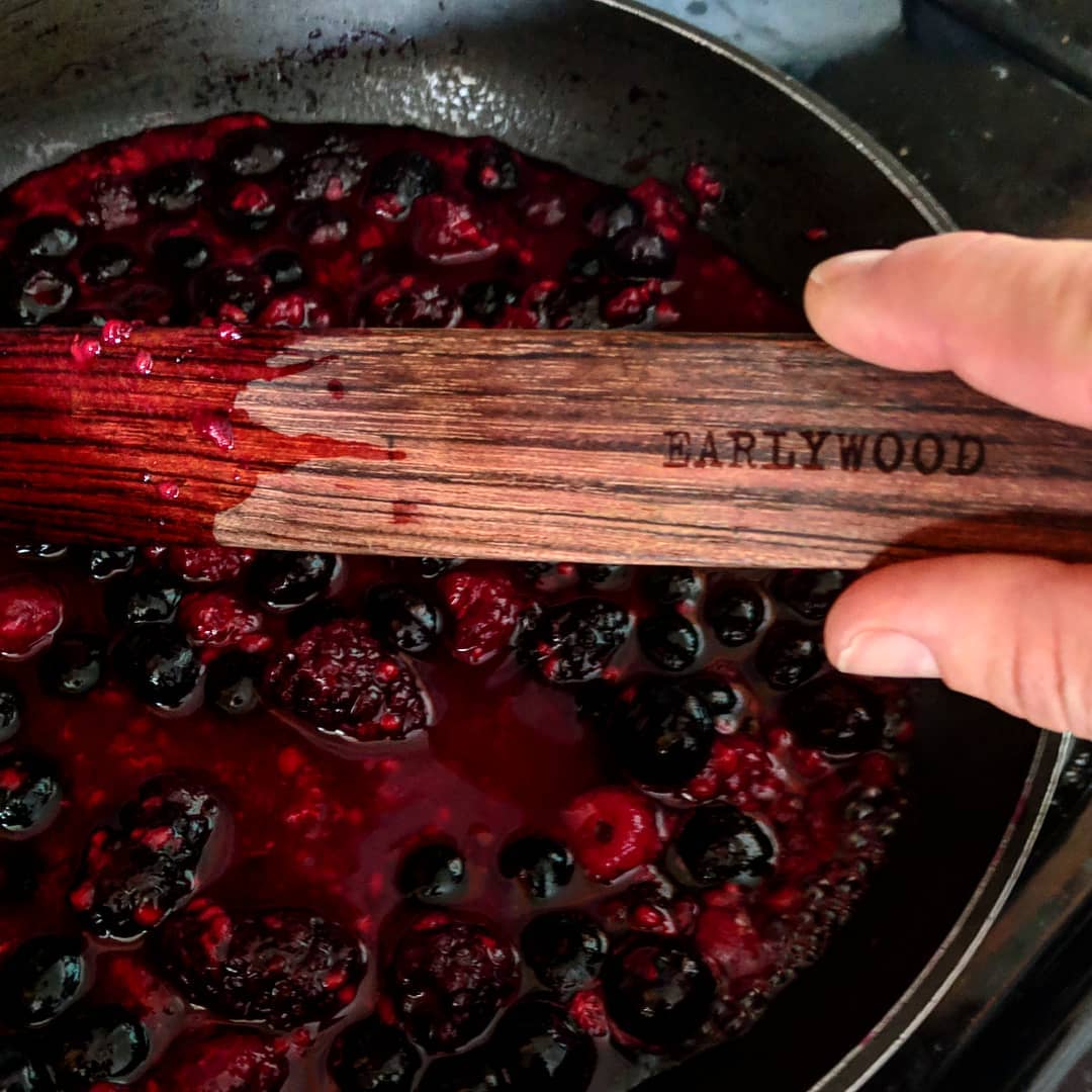 Cooking berry pancake topper using wooden spatula