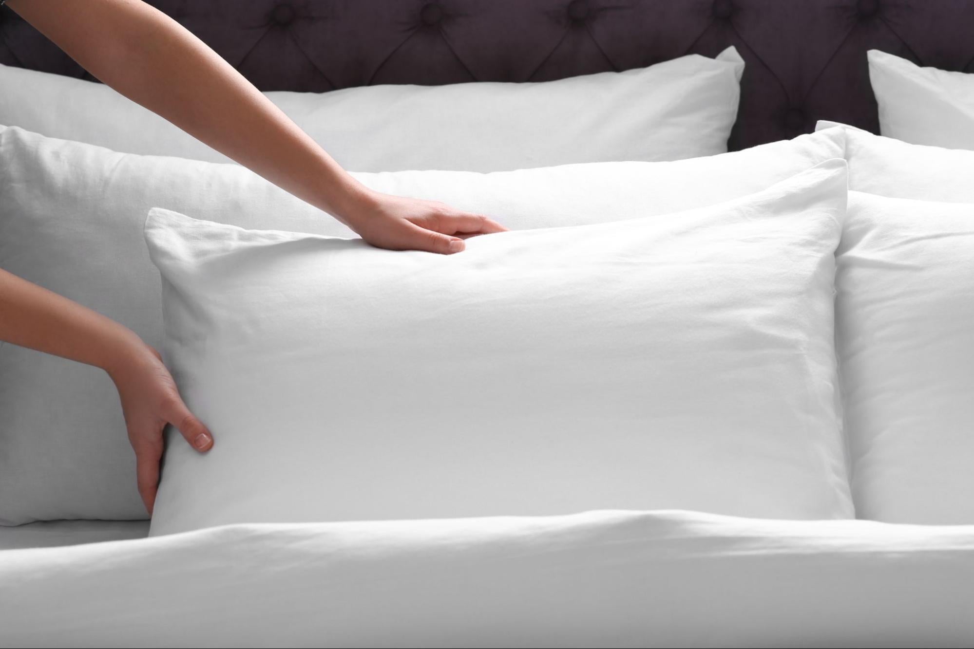 Timmins homeowner arranging pillows with white lyocell pillowcases on queen-sized bed