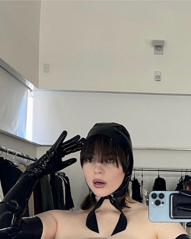 Billie Eilish wearing black Vex Opera Gloves and cap taking a behind the scenes selfie 