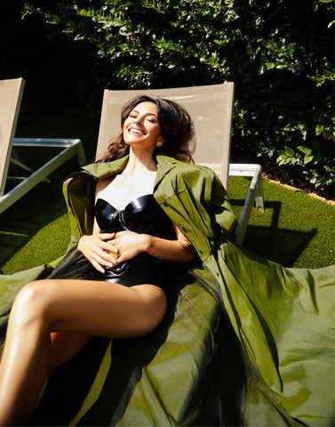 Woman wearing black Vex strapless Marilyn bodysuit lounging on a lawn chair for an interview in Photobook Magazine